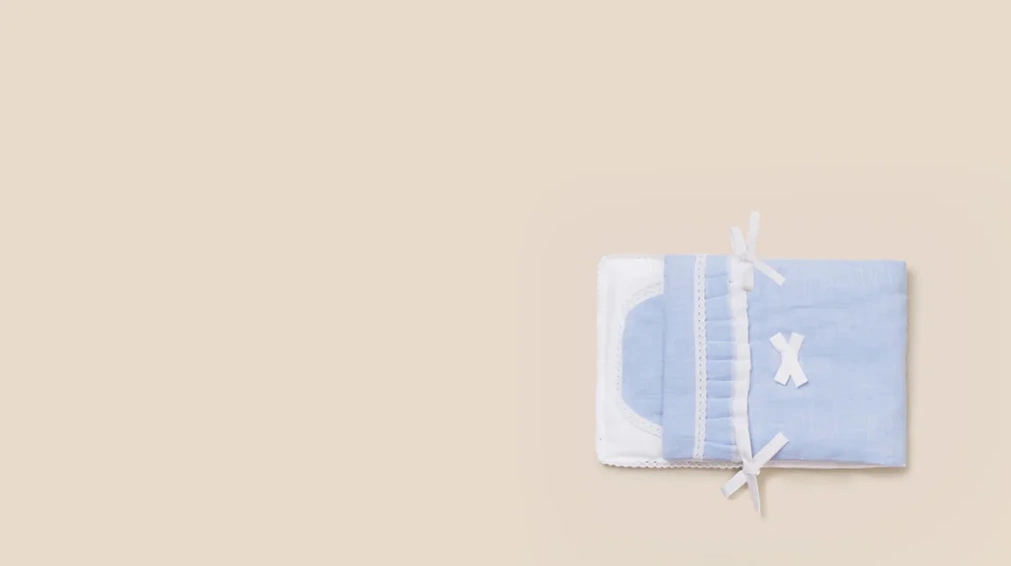 작은 아이의 몸을 감싸는 하늘색 면 수의보
