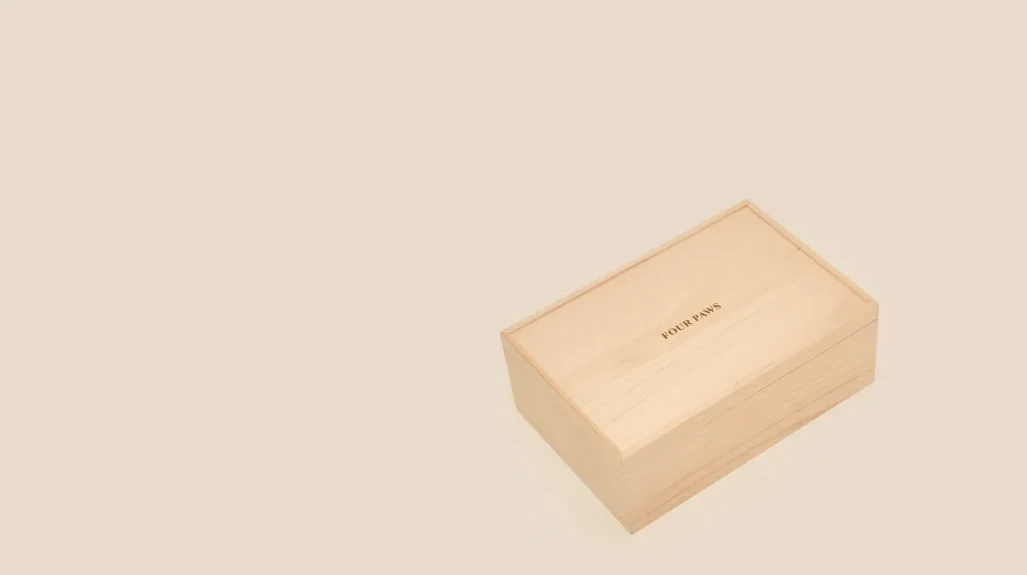 FOUR PAWS 글자가 새겨진 뚜껑 덮인 작은 나무 관