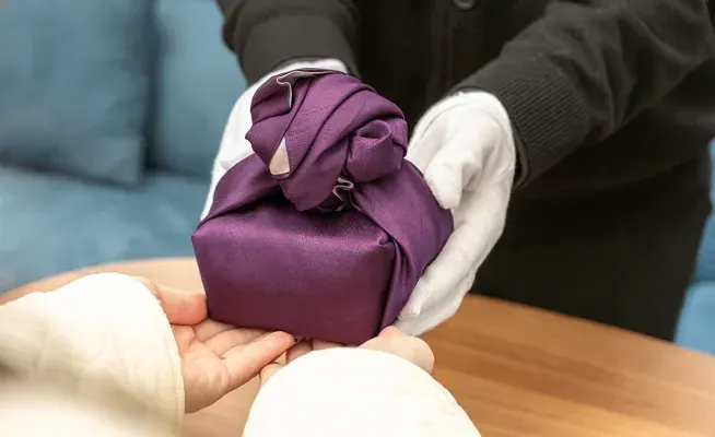 보자기에 싸인 스톤함을 장례지도사가 보호자에게 건네는 모습