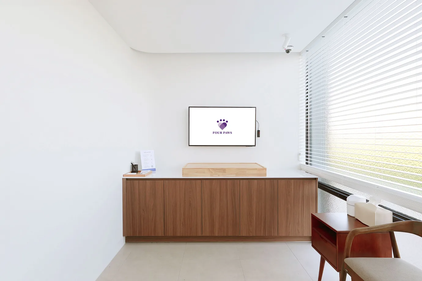 흰 벽 앞 나무 수납장 위에 얕은 나무 받침이 놓인 포포즈 화성 2호점 추모실